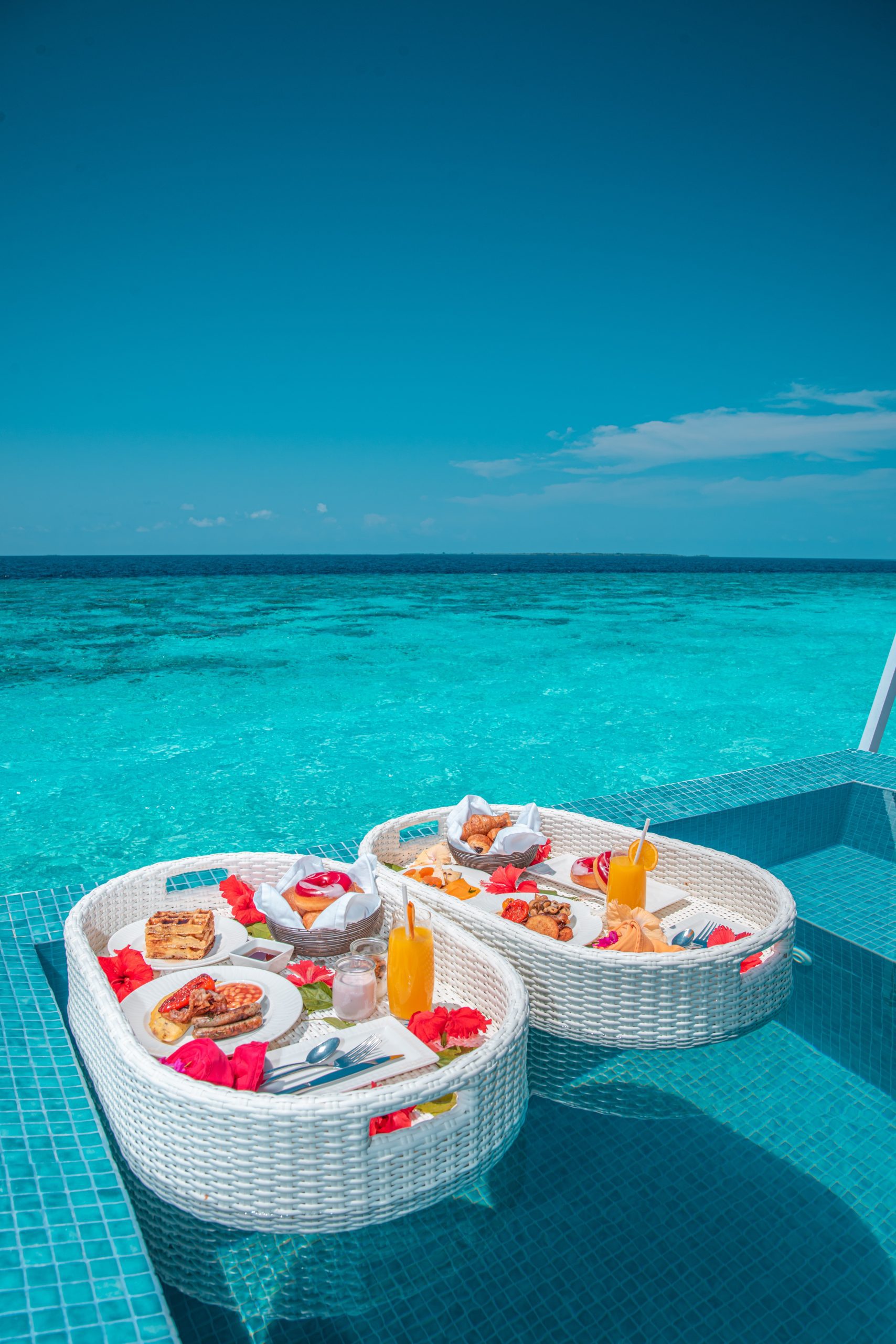 white and red plastic round table with chairs on beach during daytime maldives cities