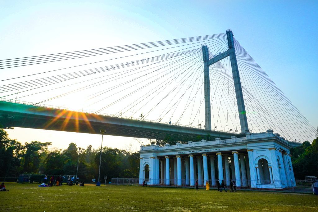 white and blue bridge under white sky during daytime kolkata cities