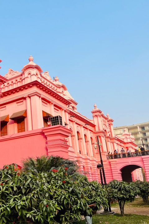 a pink building with a clock on the top of it- Ahsan Manzil
