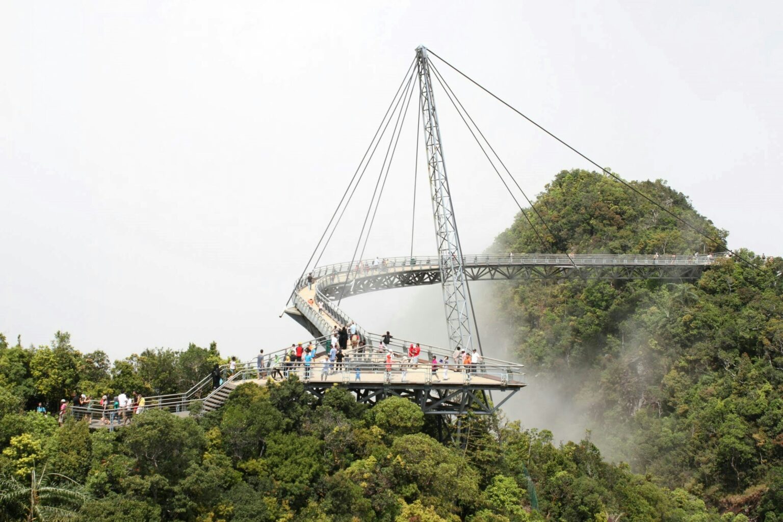 Curved metal Langkawi SkyBridge suspended high above the green mountain jungle of Machinchang mountain