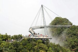 Curved metal Langkawi SkyBridge suspended high above the green mountain jungle of Machinchang mountain