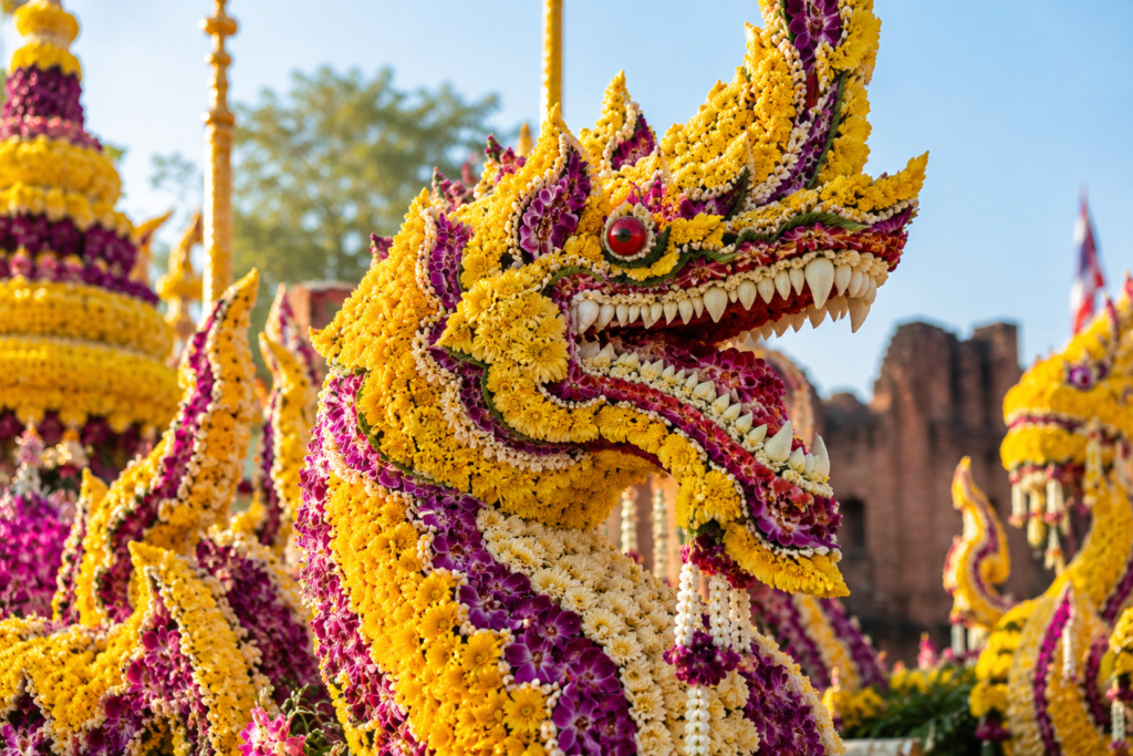 Handcrafted floral dragon sculpture covered in yellow chrysanthemum petals at Chiang Mai Flower Festival.