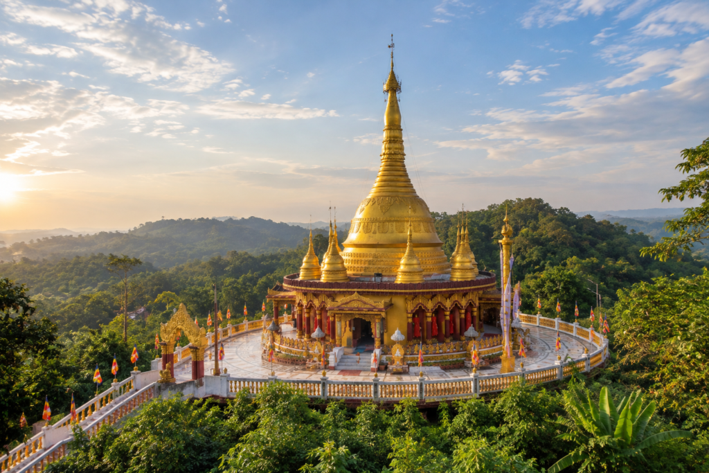 Ornate golden Buddhist pagoda with multi-tiered spires standing on a quiet hilltop in Balaghata Bandarban
