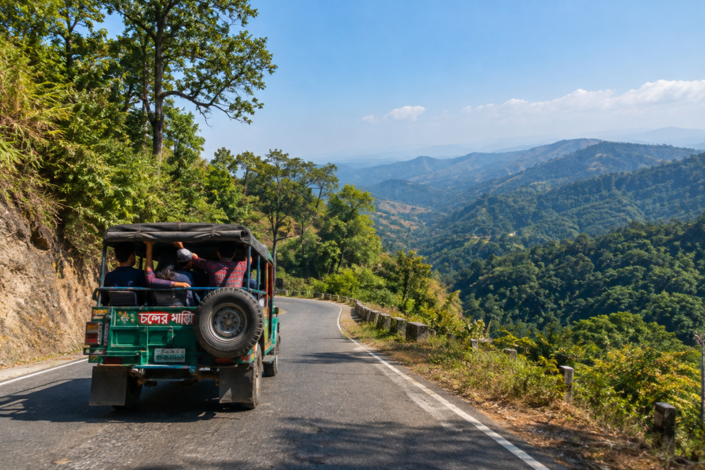 Green four-wheel-drive open Chander Gari jeep driving along a winding mountain ridge road in Bandarban