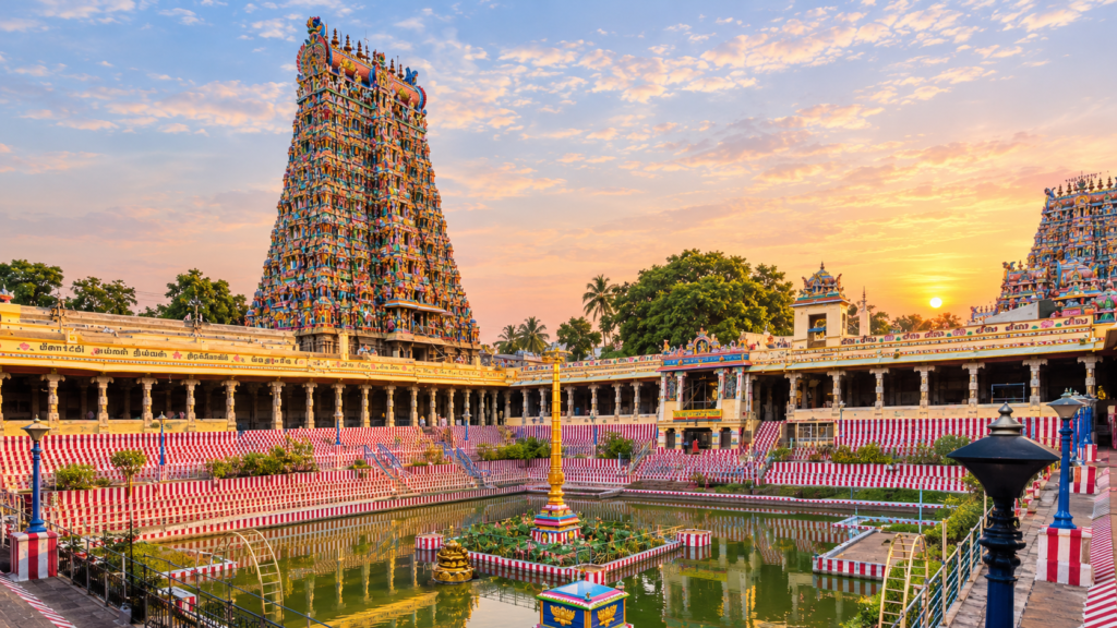 Towering ancient gopuram gateway covered in thousands of colorful sculpted figures at Meenakshi Temple in Madurai.